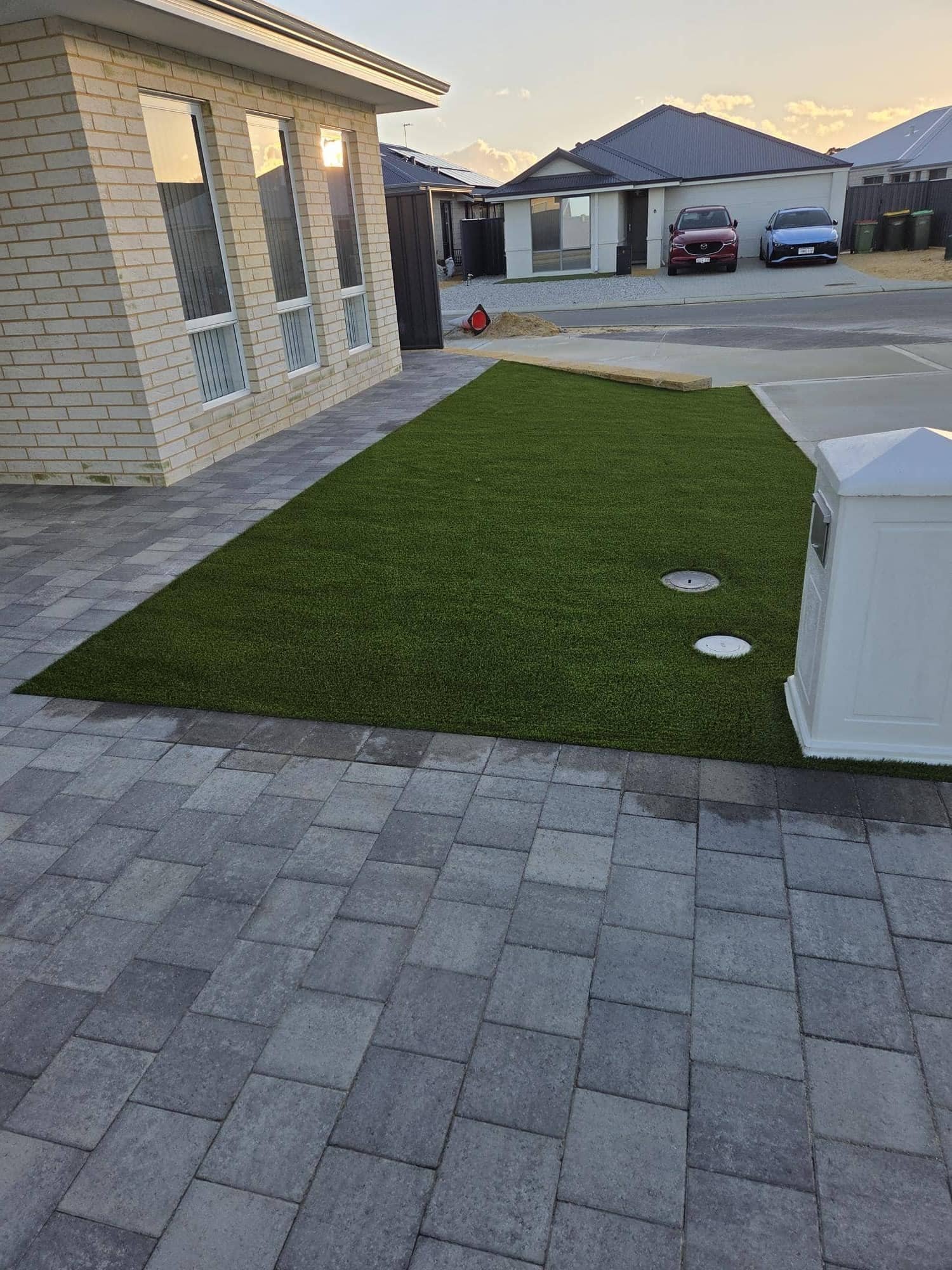 Front yard artificial turf with grey paving