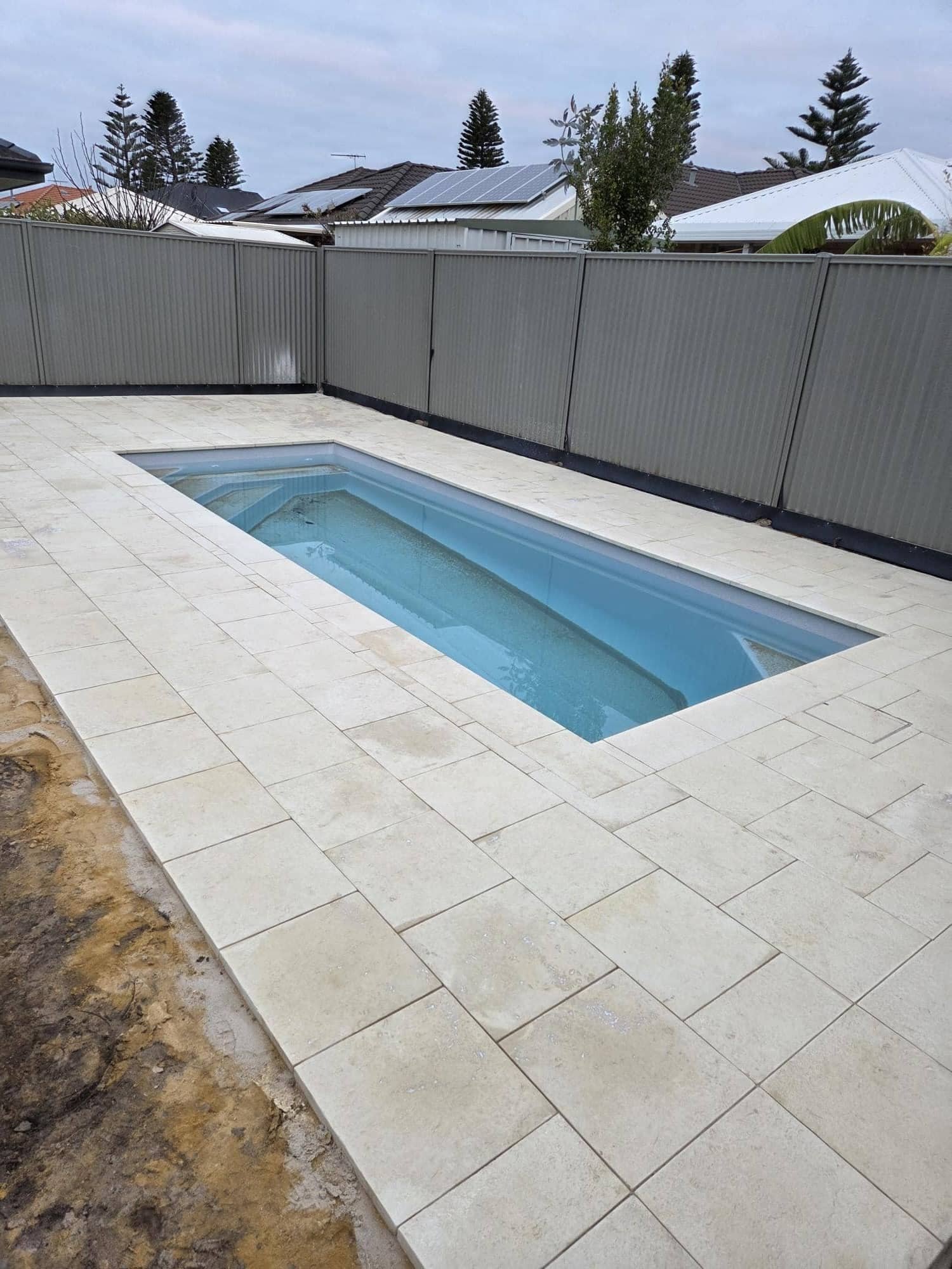 Pool surround with light stone paving